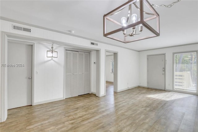 interior space featuring a notable chandelier, crown molding, and light hardwood / wood-style flooring