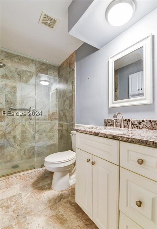 bathroom with vanity, toilet, and a tile shower