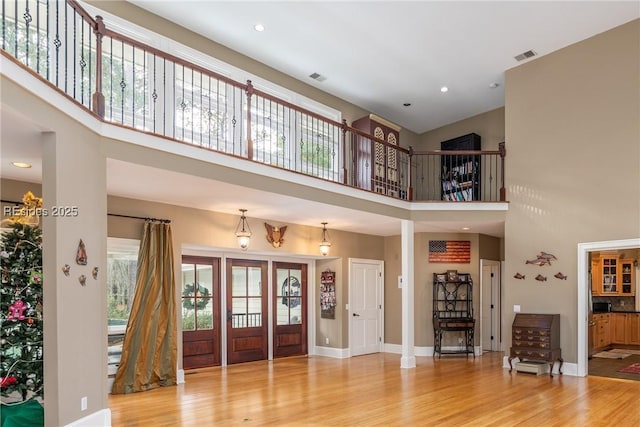 entryway featuring hardwood / wood-style flooring and a towering ceiling