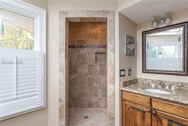 bathroom with vanity and a tile shower