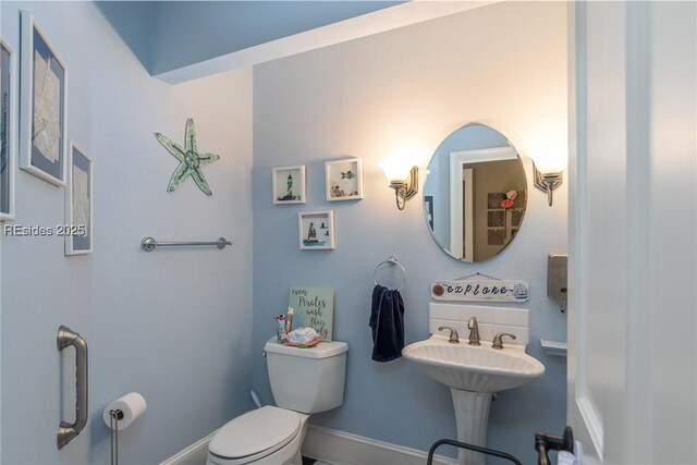 bathroom with sink, decorative backsplash, and toilet