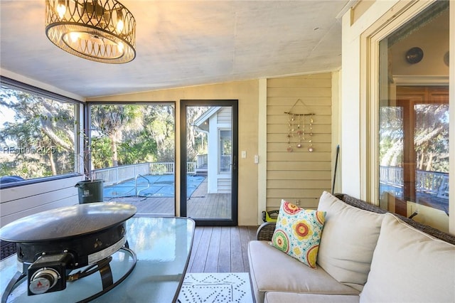 sunroom with lofted ceiling and an inviting chandelier