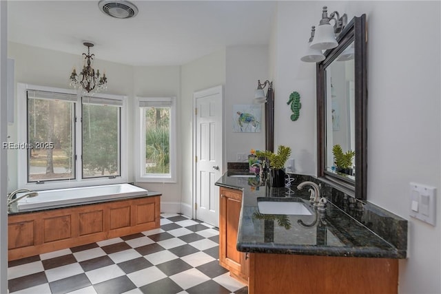 bathroom featuring an inviting chandelier, a tub to relax in, and vanity