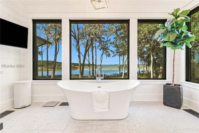 bathroom with a tub and a water view