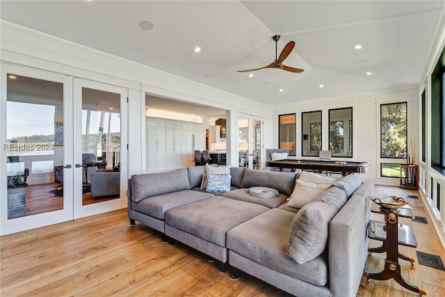 living room with light hardwood / wood-style flooring, french doors, and ceiling fan