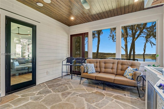 sunroom / solarium featuring wood ceiling and a water view