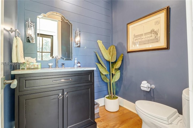 bathroom with vanity, toilet, and hardwood / wood-style floors