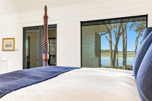 bedroom featuring a water view and access to outside