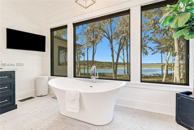 bathroom with a washtub, vanity, and a water view