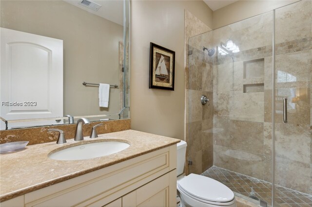 bathroom featuring vanity, toilet, and walk in shower