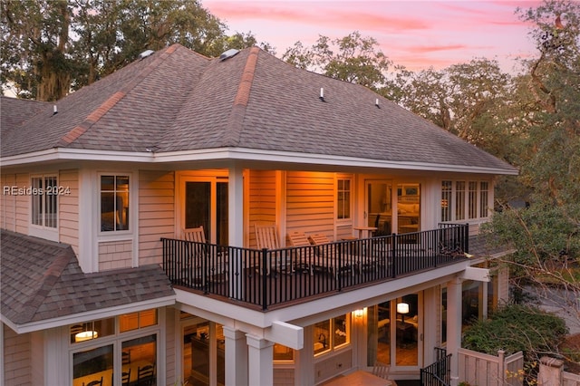 back house at dusk with a balcony