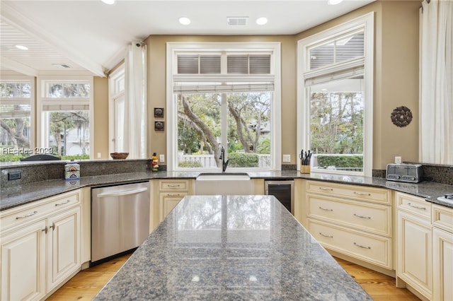 kitchen featuring beverage cooler, dishwasher, and dark stone countertops