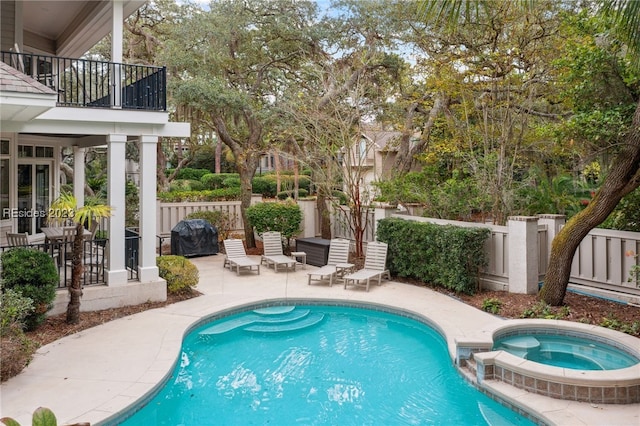 view of swimming pool with an in ground hot tub, a grill, and a patio area