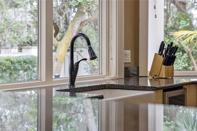 details featuring wine cooler, sink, and dark stone countertops