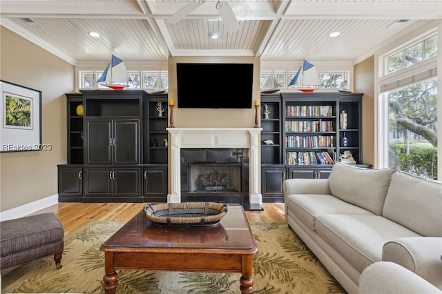 living room with coffered ceiling, crown molding, light hardwood / wood-style floors, and ceiling fan