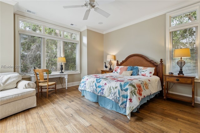 bedroom featuring crown molding, ceiling fan, wood-type flooring, and multiple windows