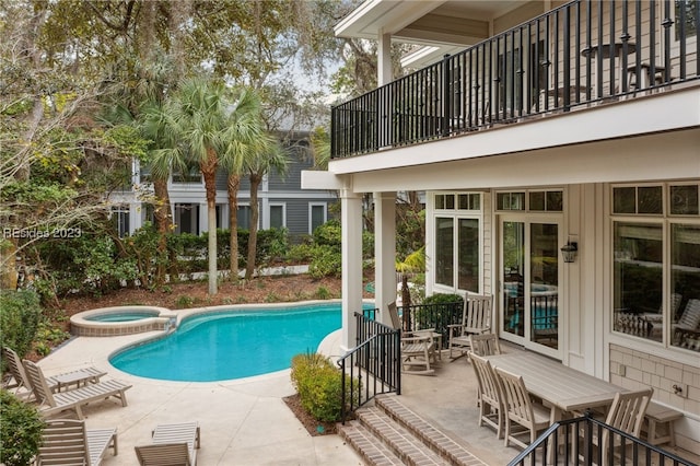 view of swimming pool featuring a patio and an in ground hot tub