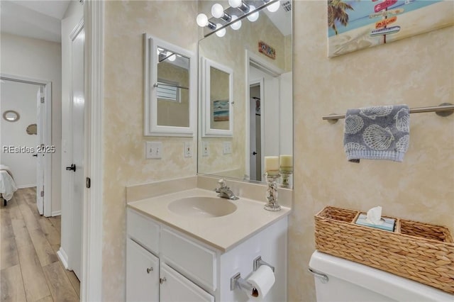 bathroom with vanity, hardwood / wood-style floors, and toilet