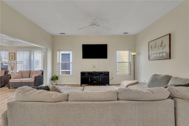 living room featuring wood-type flooring and ceiling fan