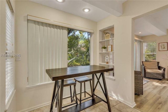 tiled dining space featuring plenty of natural light and built in shelves