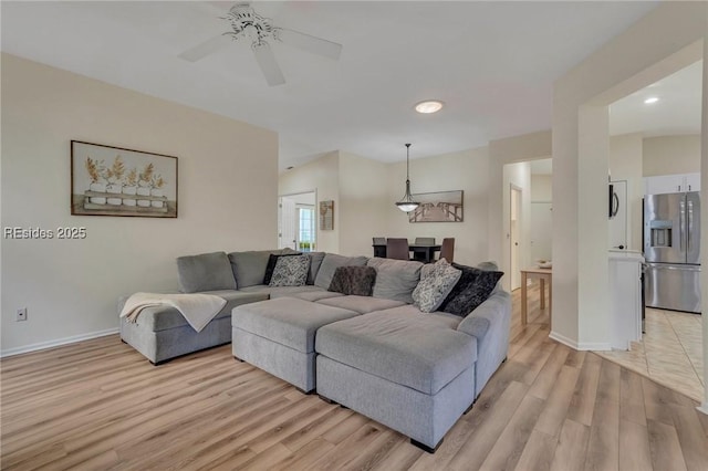 living room featuring ceiling fan and light wood-type flooring