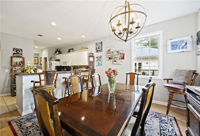 dining space featuring an inviting chandelier and light hardwood / wood-style floors