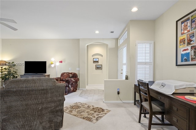 office space with ceiling fan and light carpet