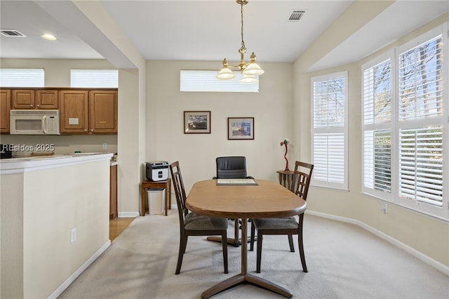 dining room featuring a notable chandelier and light colored carpet