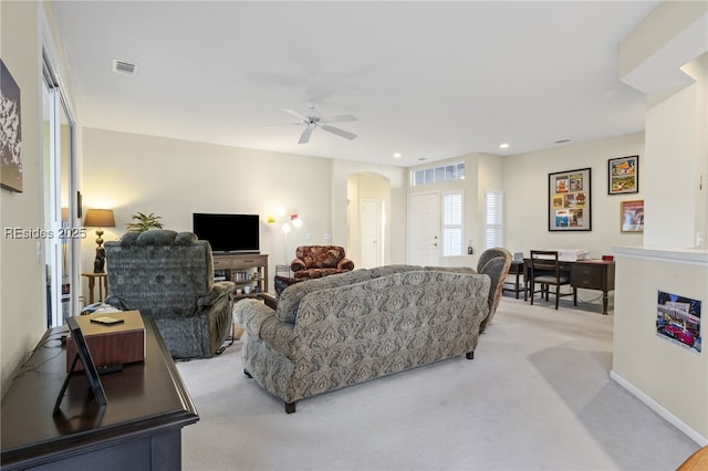 carpeted living room with ceiling fan