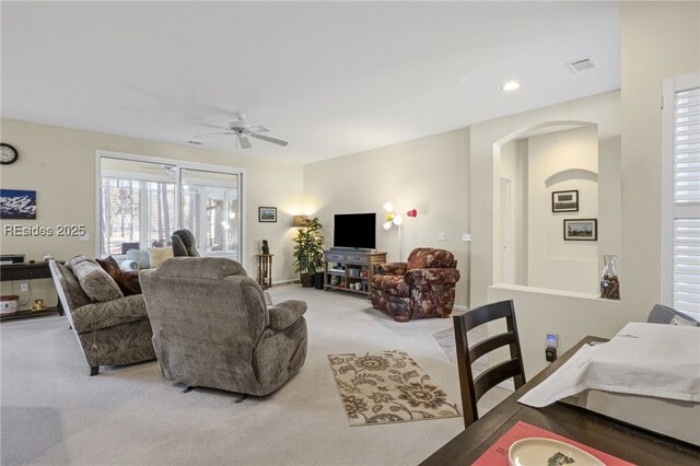 carpeted living room featuring ceiling fan