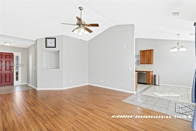 unfurnished living room with lofted ceiling, ceiling fan with notable chandelier, and light wood-type flooring