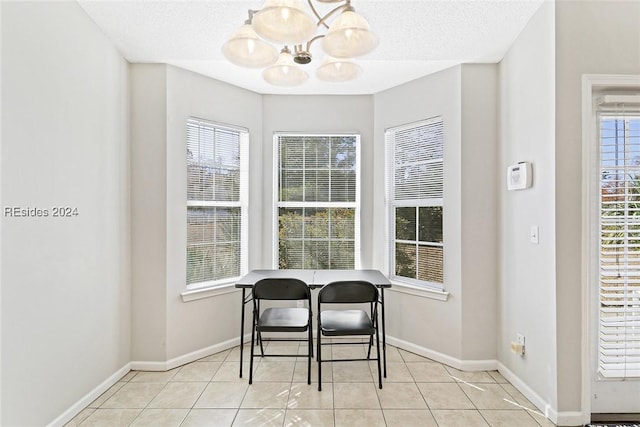 dining room featuring light tile patterned floors, a textured ceiling, and an inviting chandelier