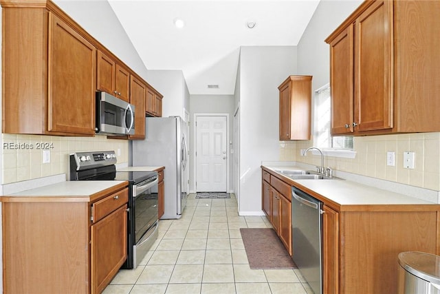 kitchen with tasteful backsplash, appliances with stainless steel finishes, sink, and light tile patterned floors