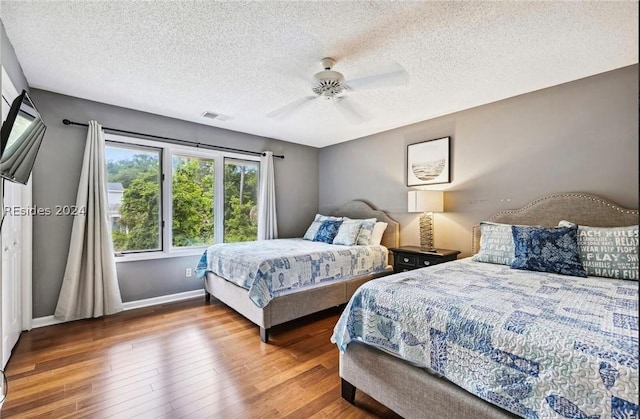 bedroom featuring a textured ceiling, wood-type flooring, and ceiling fan