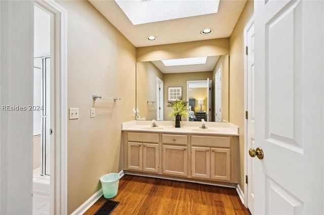 bathroom with vanity, hardwood / wood-style floors, and a skylight