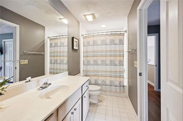 full bathroom with shower / bathtub combination with curtain, tile patterned flooring, vanity, a textured ceiling, and toilet