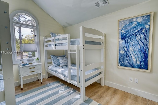 bedroom with vaulted ceiling and light hardwood / wood-style floors