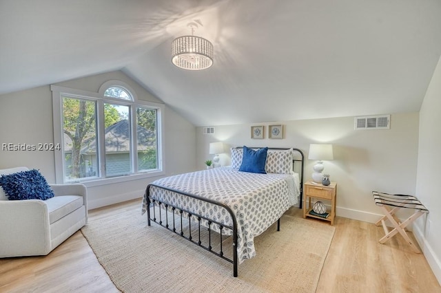 bedroom featuring lofted ceiling and light wood-type flooring