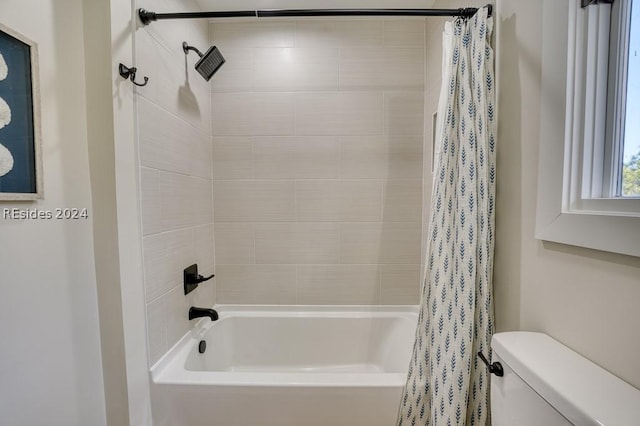 bathroom with toilet and shower / bath combo with shower curtain