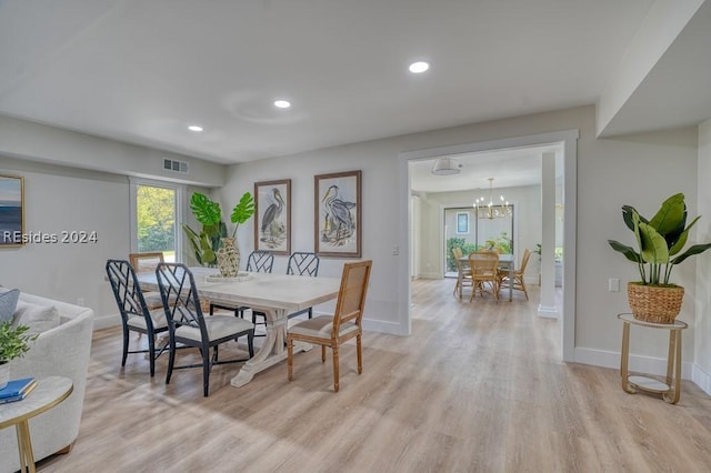 dining area with a chandelier and light hardwood / wood-style floors