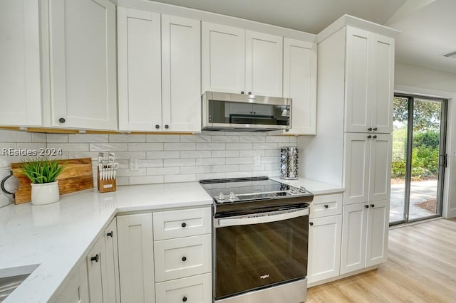 kitchen featuring white cabinetry, light stone countertops, tasteful backsplash, and stainless steel appliances