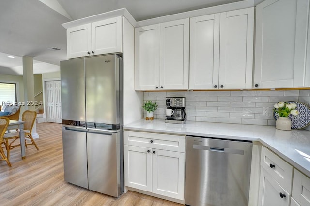 kitchen featuring tasteful backsplash, white cabinetry, and appliances with stainless steel finishes