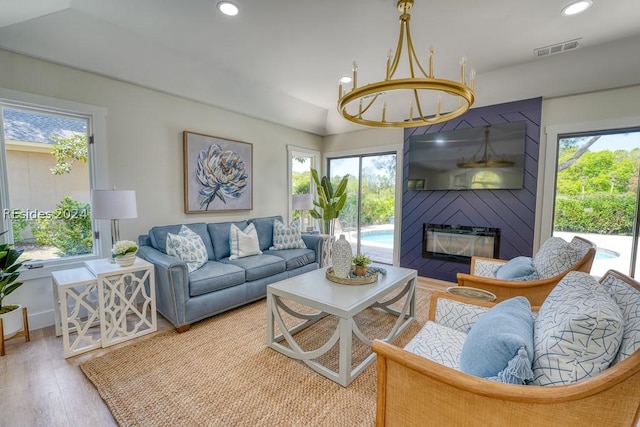 living room featuring hardwood / wood-style flooring, a large fireplace, and vaulted ceiling