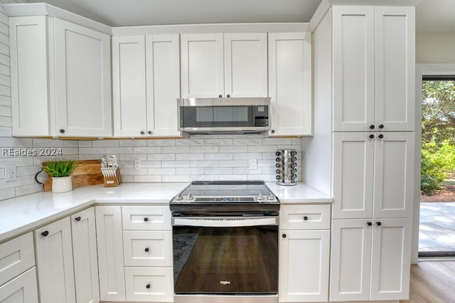 kitchen with appliances with stainless steel finishes, decorative backsplash, and white cabinets