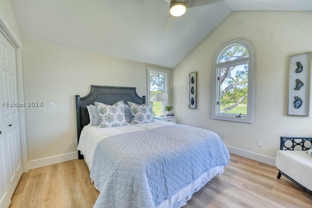 bedroom with ceiling fan, lofted ceiling, a closet, and light wood-type flooring