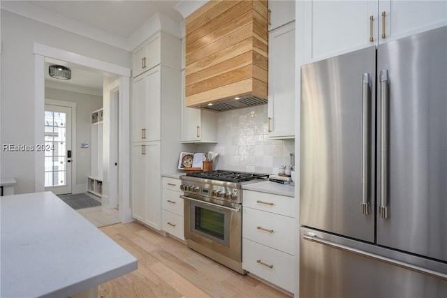 kitchen with white cabinets, custom exhaust hood, and high quality appliances