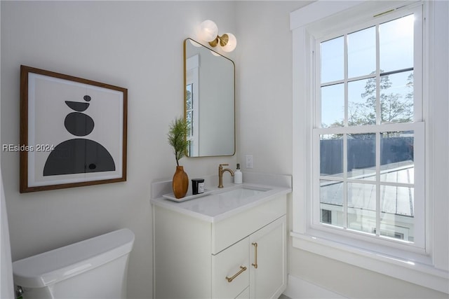 bathroom featuring vanity, plenty of natural light, and toilet