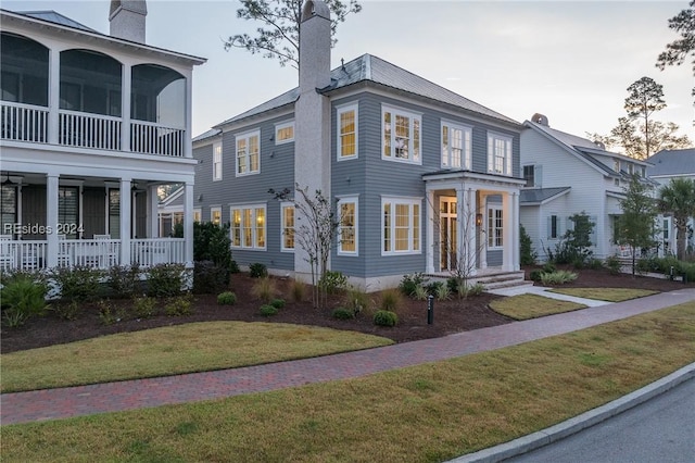 view of front of house with a front yard and a sunroom