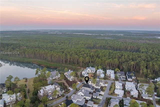 aerial view at dusk featuring a water view