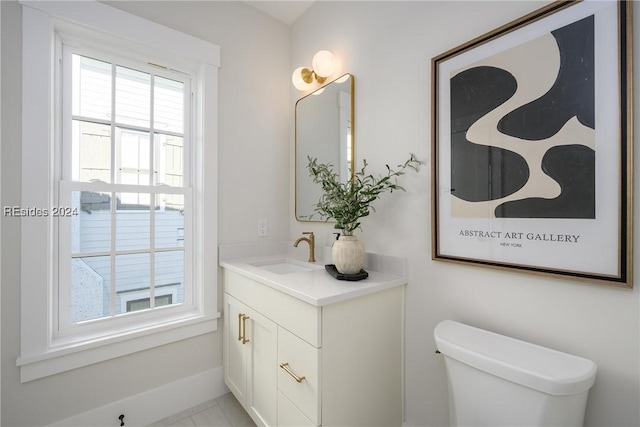 bathroom featuring vanity, plenty of natural light, and toilet